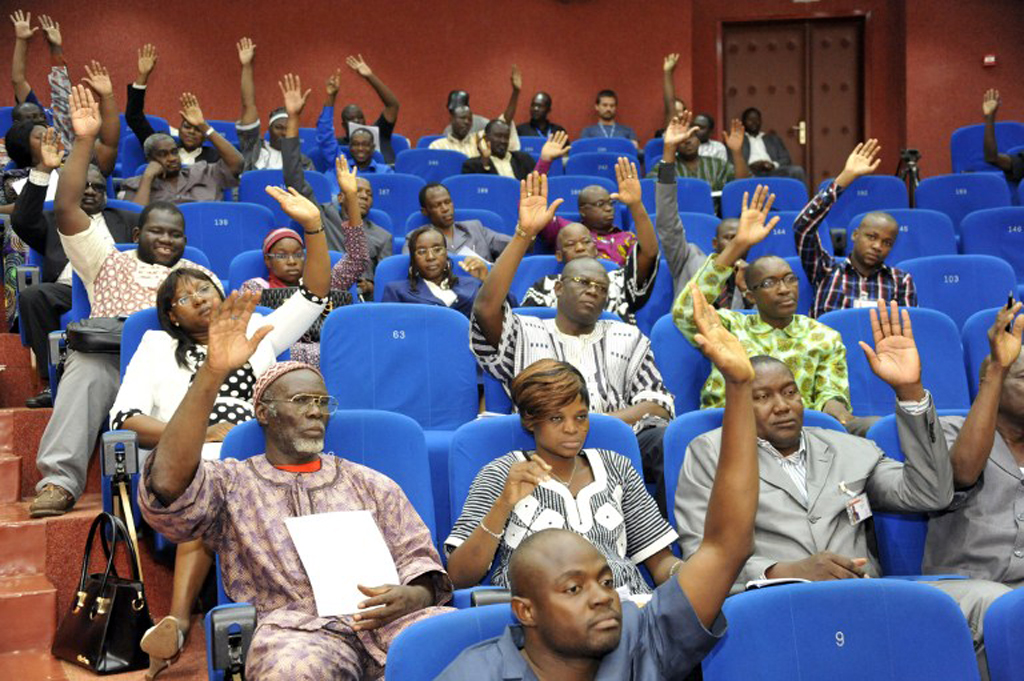Members of Burkina Faso's interim parliament raise their hands on July 16, 2015 in Ouagadougou as they vote on a resolution asking the High Court to put deposed leader Blaise Compaore on trial for "high treason" and violating the constitution. (photo credit: AFP)