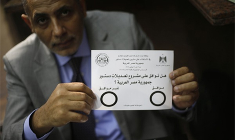 An Egyptian man displays the voting paper of a referendum on the new constitutio