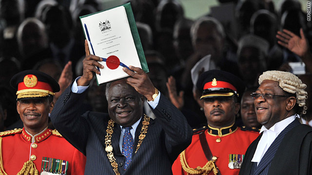 Former President Mwai Kibaki holds newly promulgated constitution [photo credit: CNN]