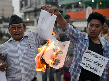 Nepali activists burn a copy of the draft constitution (photo credit: AFP)