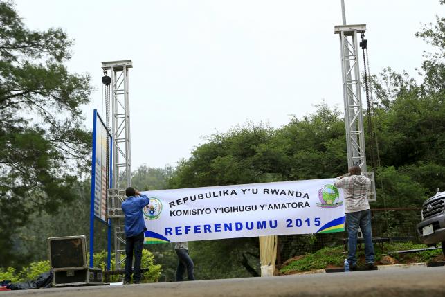 People erect a banner at the entrance of a polling station on the eve of a referendum as Rwandans will vote to amend its Constitution to allow President Paul Kagame to seek a third term in Rwanda capital Kigali, December 17, 2015. (photo credit: Reuters)