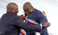 Congolese President Felix Tshisekedi, right, receives the presidential sash from outgoing president Joseph Kabila (photo credit: AP)