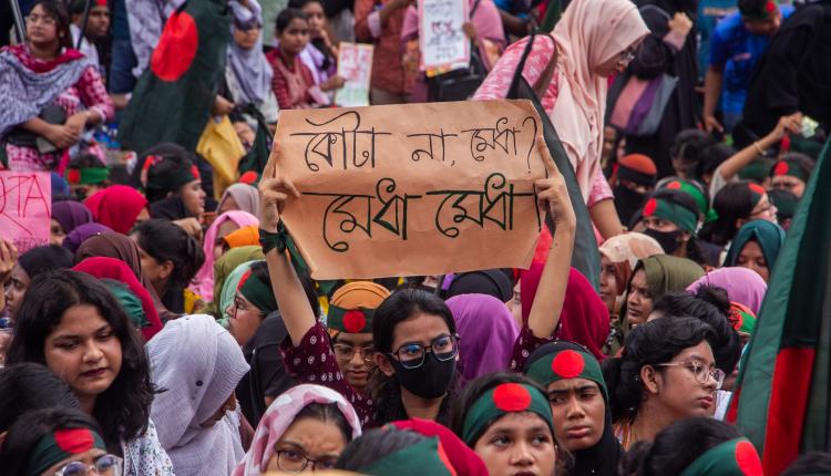 Quota reform protest in Bangladesh with a sign reading "Not quotas, merit!" (photo credit: Rayhan9d via Wikimedia Commons)