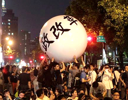 Activists push a ball reading ‘Constitutional Reform’ during a sit-in to mark the one-year anniversary of the start of the Sunflower Movement outside the Legislative Yuan in Taipei (18 March 2015) photo credit: REUTERS