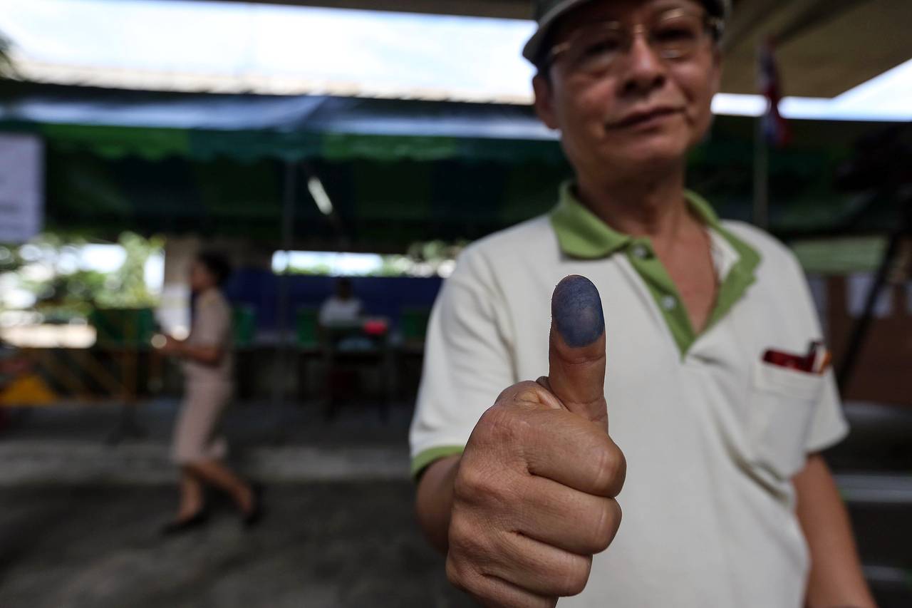 A man displays his inked thumb after voting in Thailand's constitutional referendum (photo credit: BLOOMBERG NEWS)