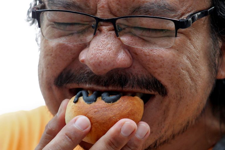 A man eats bread with 'No' written on it during a campaign against the draft constitution (photo credit: Reuters)