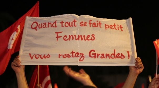 A Tunisian sign-bearer's message reads: "When everything becomes small, women remain strong." Amine Ghrabi / Flickr / CC 